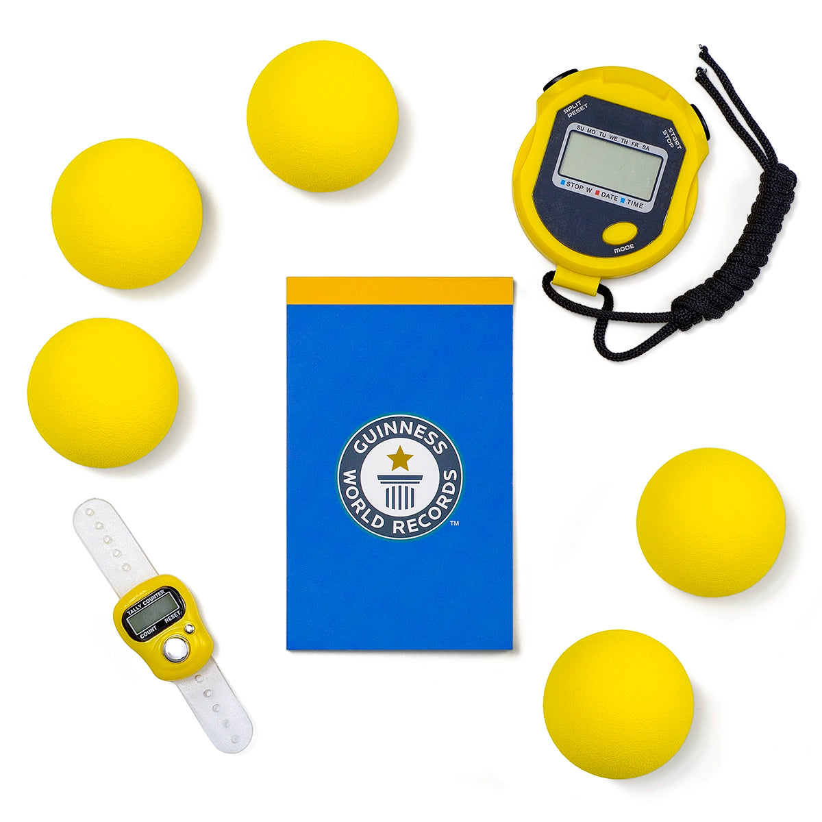 Yellow balls, blue book with Guinness World Records logo, digital stopwatch, and white watch on a white background
