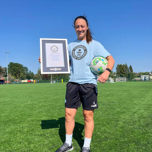 Megan Campbell in a light blue Guinness World Records top holding her record holder certificate 