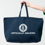 Oversized Guinness World Records navy tote bag with model hand holding it up 