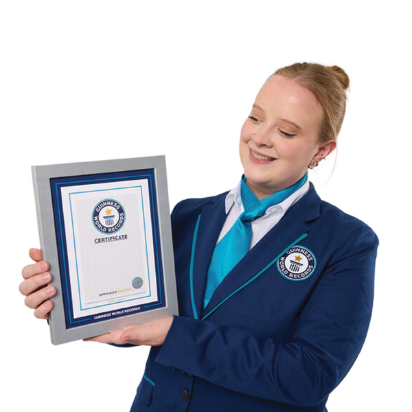 female adjudicator in a Guinness World Records uniform holding a Record Participant Certificate in it's frame with a white background