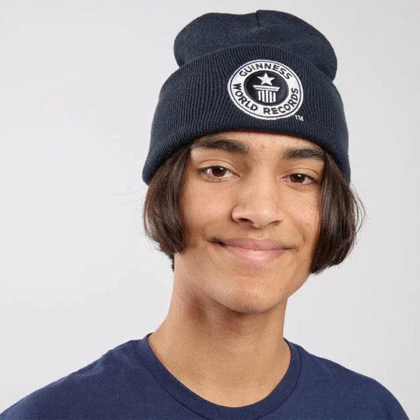 Person wearing a navy blue beanie with Guinness World Records logo on a light gray background