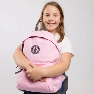 Girl holding a pink backpack with a black GWR logo on a light gray background