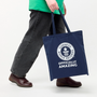 Person holding a navy tote bag with Guinness World Records logo on a white background